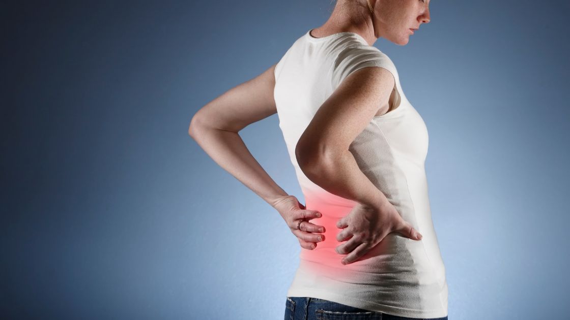 Pessoa tensa a aliviar o stress com respiração, sugerindo a ligação entre stress e dor nas costas